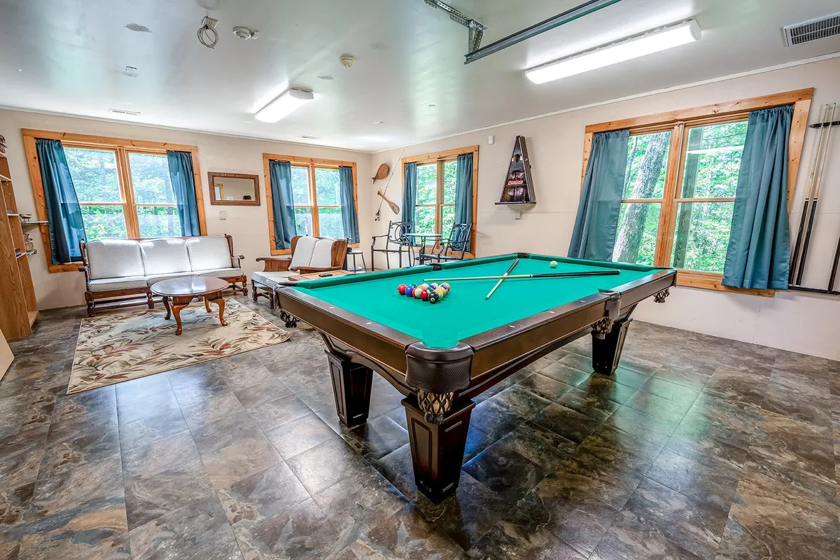 An interior view of the private game room, complete with a pool table, windows that let in natural light, and comfortable seating for the whole family. The playful setup invites both kids and adults to enjoy hours of entertainment after returning from local attractions.